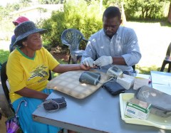 Doris Dhlamini has her blood sugar tested by Jonathan, who is pinch hitting for retired nurse Cornelia. 