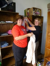 Joy Comley (right) and friend Ena Chandler begin to set up the Clothes Bank. 