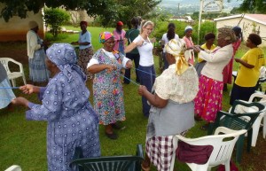 In pairs, gogos use rubber tubing to help each other strengthen muscles.